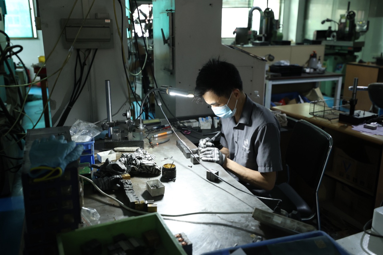 技师在工作台进行钻尾模具加工与检查